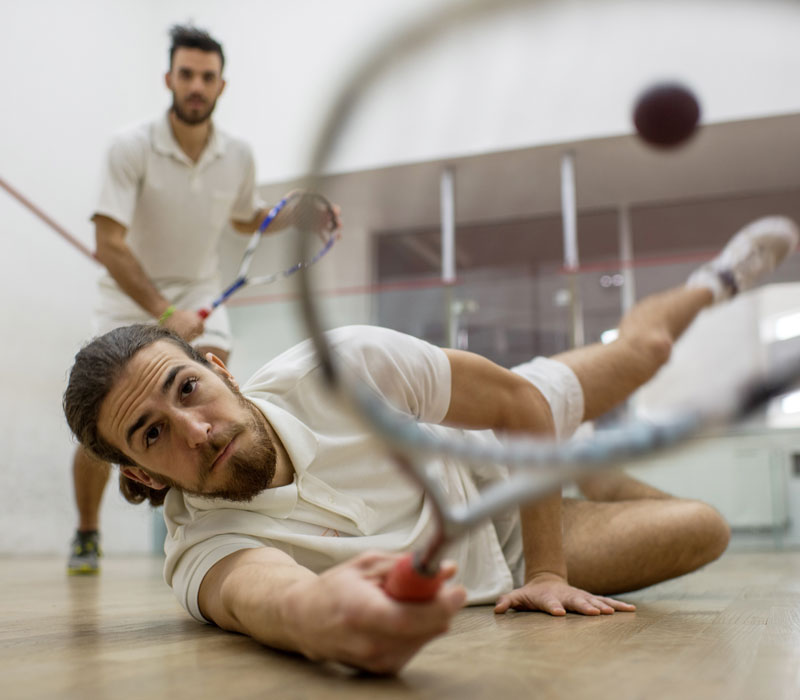 two men playing squash competitively